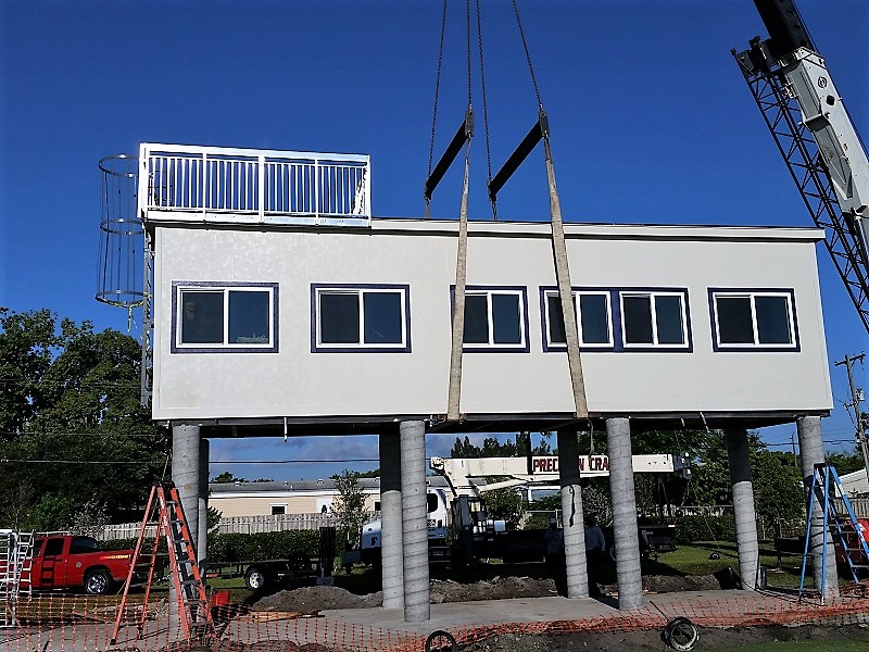 Crane setting prefabricated pressbox onto cement columns